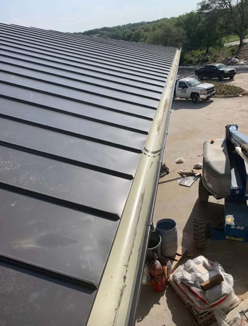 Standing seam panel and gutter detail on a metal roofing jobsite in Grants Pass